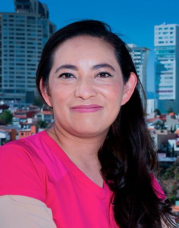 Es la foto de perfil de un psiquiatra en Huixquilucan. Tiene el cabello largo, ondulado y negro. Usa un uniforme médico rosa.