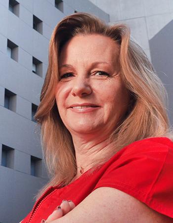 Es la foto de perfil de una médica general en Huixquilucan. Usa un uniforme rojo, tiene el cabello pelirrojo y está sonriendo.