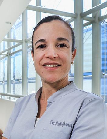 Es la foto de perfil de una pediatra en Huixquilucan. Usa un uniforme médico azul claro, está sonriendo, tiene el cabello recogido y está usando aretes.