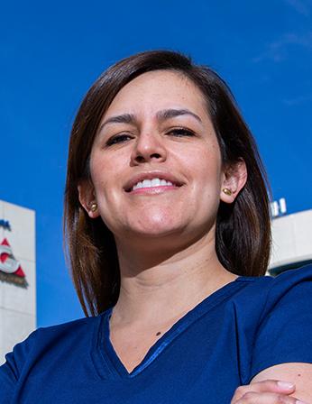 Es la foto de perfil de una otorrinolaringóloga en Huixquilucan de Hospital Angeles Lomas. Utiliza un uniforme azul, tiene el cabello largo, lacio y castaño oscuro, está sonriendo.