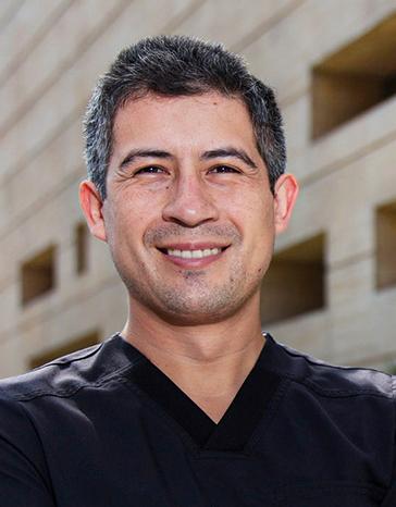 Es la foto de perfil de un internista, gastroenterólogo y endoscopista en Ciudad de México de Hospital Angeles. Viste un uniforme negro y está sonriendo. 