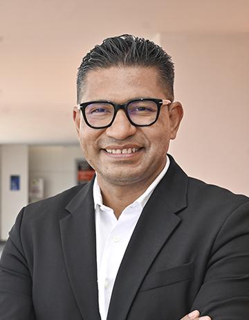 Es la foto de perfil de un urólogo pediátrico en León de Hospital Angeles León. Utiliza un saco negro, tiene una camisa blanca y lentes con marco negro,