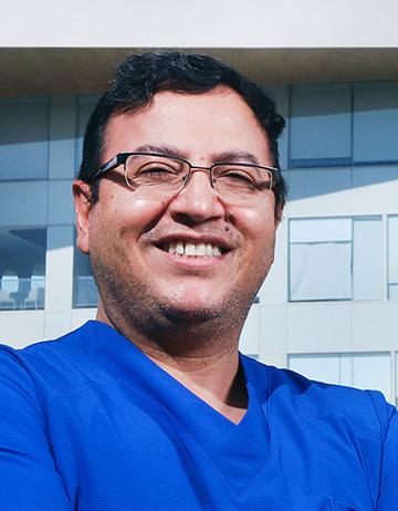 Es la foto de perfil de un urólogo en Ciudad de México de Hospital Angeles. El doctor viste un uniforme azul, está sonriendo y usa lentes.