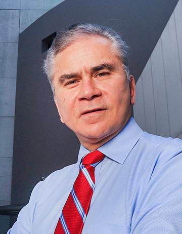 Es la foto de perfil de un ortopedista y traumatólogo en Huixquilucan de Hospital Angeles Lomas. Usa una camisa azul con una corbata roja y rayas azules.