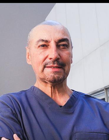 Es la foto de perfil de un otorrinolaringólogo en Huixquilucan de Hospital Angeles Lomas. Usa un uniforme azul con cuello V, es calvo y está sonriendo.