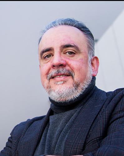 Es la foto de perfil de un pediatra y neonatólogo en Huixquilucan de Hospital Angeles Lomas. Usa un suéter negro con un saco negro, es canoso y está sonriendo. 