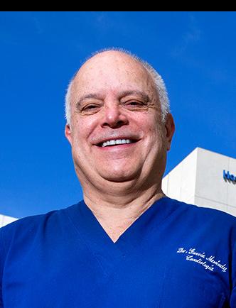 Es la foto de perfil de un cardiólogo en Huixquilucan de Hospital Angeles Lomas. Usa un uniforme azul y está sonriendo.
