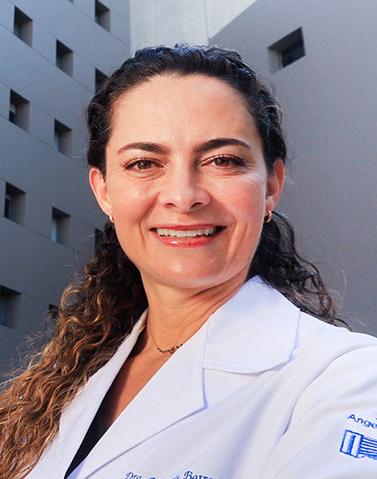 Es la foto de perfil de una periodoncista en Huixquilucan de Hospital Angeles Lomas. Usa una bata, tiene el cabello semirecogido, usa bata blanca y su cabello es rizado.