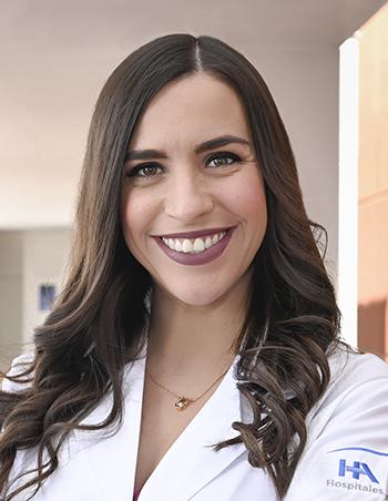 Es la foto de perfil de una ginecóloga y obstetra en León de Hospital Angeles León. Utiliza una bata blanca, tiene el cabello largo, castaño y está sonriendo.