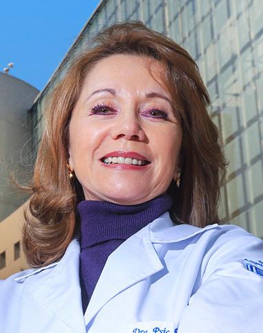 Es la foto de perfil de una psicóloga en Huixquilucan de Hospital Angeles Lomas. Usa una bata blanca, cuello azul marino de tortuga y tiene cabello rubio.