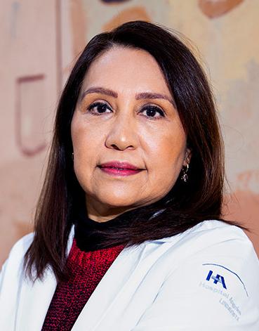 Es la foto de perfil de una ginecóloga y obstetra en Ciudad de México de Hospital Angeles Lindavista. Tiene el cabello corto y negro. Usa una bata blanca, un suéter rojo y una blusa de cuello alto negro.
