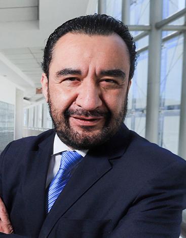 Es la foto de perfil de un urólogo en Ciudad de México de Hospital Angeles. Viste un traje negro, camisa blanca y una corbata azul brillante. Brinda sus servicios en Hospital Angeles Acoxpa y del Carmen.