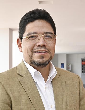 Es la foto de perfil de un urólogo en León de Hospital Angeles León. Porta un saco color camel y unos lentes. Tiene el cabello corto y negro.