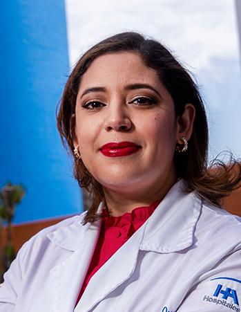Es la foto de perfil de una hematóloga en Tijuana de Hospital Angeles Tijuana. Usa una bata color blanco y una blusa roja. Tiene el cabello café.