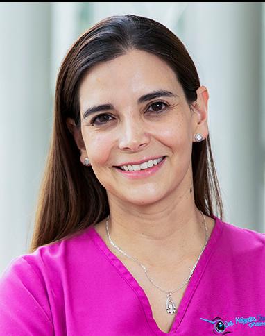 Es la foto de perfil de una oftalmóloga en Huixquilucan. Tiene el cabello largo café. Usa un uniforme médico rosa. Está sonriendo.