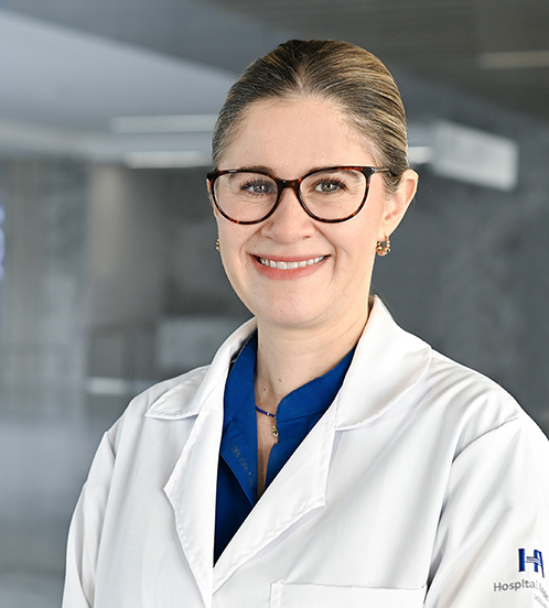 Es la foto de perfil de una pediatra en Querétaro de Hospital Angeles Centro Sur. Tiene el cabello rubio, ondulado, es de tez blanca, está sonriendo y usa una bata blanca.