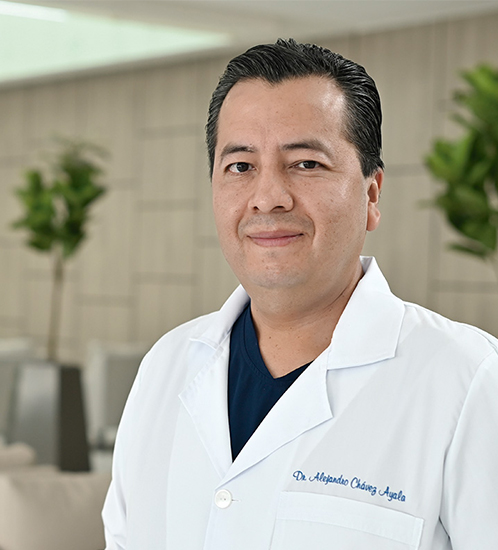 Es la foto de perfil de un gastroenterólogo en Querétaro de Hospital Angeles Centro Sur. Tiene una bata blanca, playera azul marino y es de tez morena.