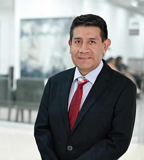 Es la foto de perfil de un endoscopista y cirujano general en Ciudad de México de Hospital Angeles. Es la imagen de un doctor con un estetoscopio en la mano izquierda, figurando que se toma el codo del brazo derecho, la fotografía está tomada en un cuarto del cuerpo del doctor. 