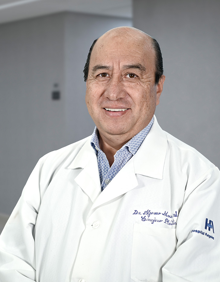 Es la foto de perfil de un cirujano plástico en Ciudad de México de Hospital Angeles Lindavista. Usa lentes, una bata blanca, una camisa azul claro y una corbata naranja con estampado.