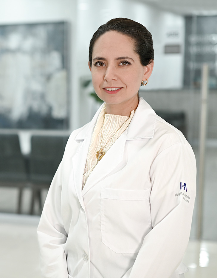 Es la foto de perfil de una endocrinóloga en Ciudad de México de Hospital Angeles Acoxpa. Usa una bata blanca con una blusa color beige. Tiene puesto joyería dorada y tiene el cabello recogido en un chongo.