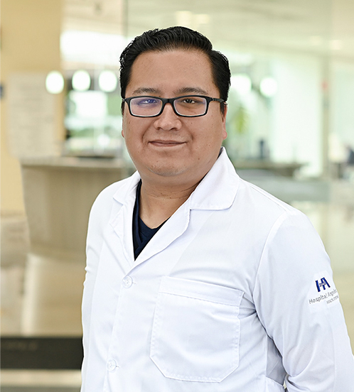 Es la foto de perfil de un ortopedista y traumatólogo pediatra en Ciudad de México de Hospital Angeles Acoxpa. Usa una bata médica con un uniforme médico color azul oscuro. Tiene el cabello negro. Usa lentes con armazón negro.
