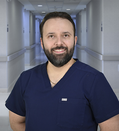 Es la foto de perfil de un otorrinolaringólogo en Ciudad Juárez de Hospital Angeles Ciudad Juárez. Usa un uniforme gris, tiene barba y cabello oscuro.