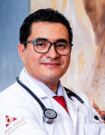 Es la foto de perfil de un cardiólogo en León de Hospital Angeles León. Usa una bata blanca con camisa y corbata. Usa un estetoscopio y tiene lentes.