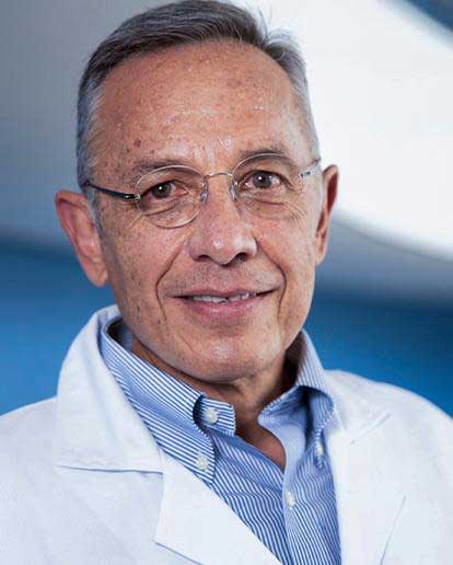 Es la foto de perfil de un urólogo en Huixquilucan. Usa una bata blanca con una camisa azul, tiene lentes y el cabello canoso.