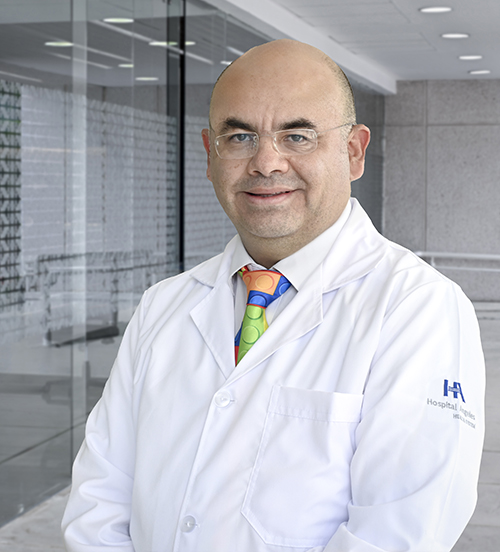 Es la foto de perfil de un pediatra en Villahermosa de Hospital Angeles Villahermosa. Usa una bata blanca y una corbata azul. Tiene los brazos cruzados.