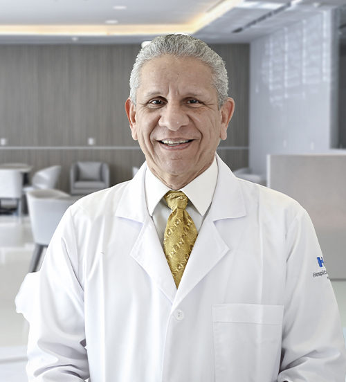 Es la foto de perfil de un neumólogo en San Pedro Garza de Hospital Angeles Valle Oriente. Usa una bata blanca y una corbata naranja. Tiene el cabello gris y está sonriendo.