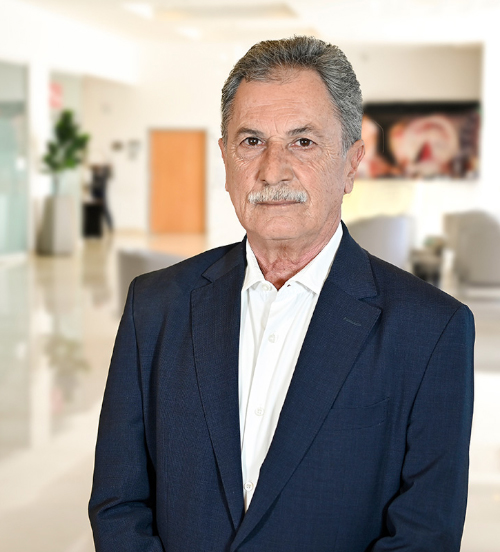 Es la foto de perfil de un cirujano plástico en Xalapa de Hospital Angeles Xalapa. Usa un saco azul y camisa blanca. Tiene el cabello y bigote gris.