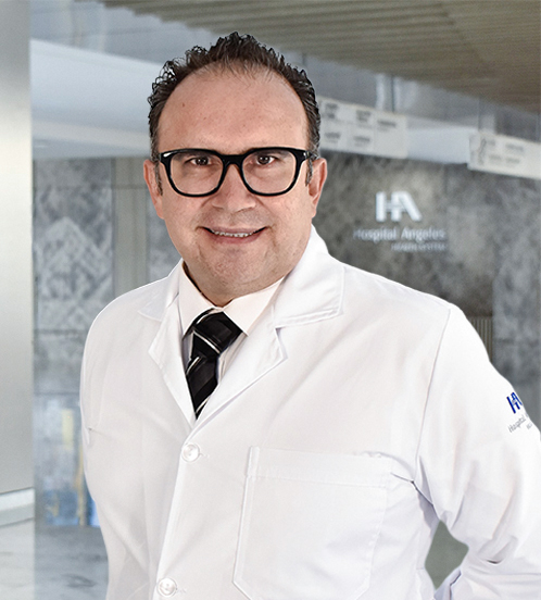 Es la foto de perfil de un neonatólogo en Querétaro de Hospital Angeles Centro Sur. Usa una bata blanca, una camisa blanca y una corbata azul cielo con líneas doradas y negras.