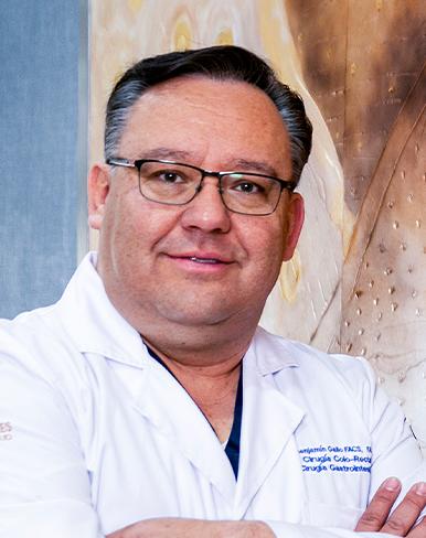 Es la foto de perfil de un coloproctólogo en León de Hospital Angeles León. Utiliza una bata blanca, utiliza lentes, tiene los brazos cruzados.