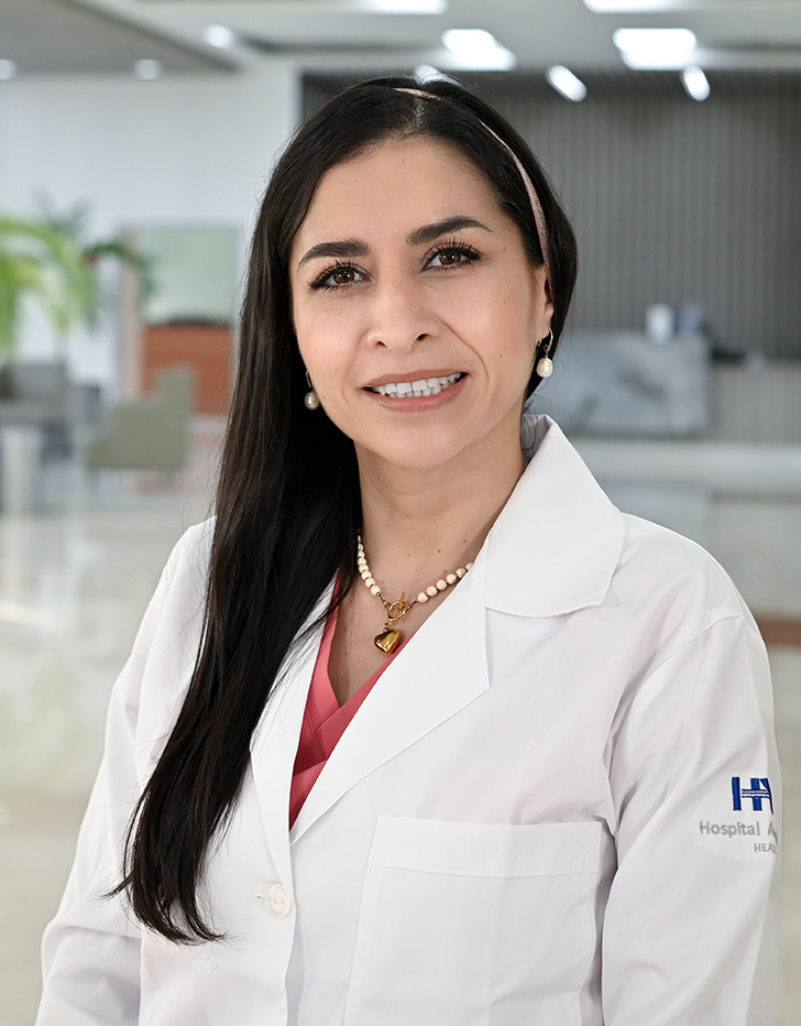 Es la foto de perfil de una médica internista, especialista en ecocardiografía y cardióloga en Tampico de Hospital Angeles Tampico. Usa una bata blanca con una blusa azul. Tiene el cabello largo y café.