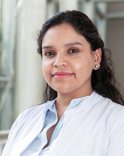 Es la foto de perfil de una ortopedista y traumatóloga en Huixquilucan de Hospital Angeles Lomas. Usa una bata blanca con una camisa clara, cabello largo ondulado y oscuro. Es sonriendo ligeramente.