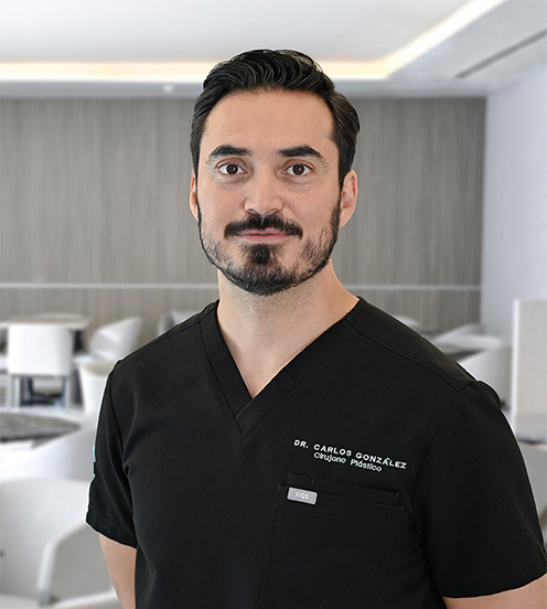 Es la foto de perfil de un cirujano plástico en San Pedro Garza García de Hospital Angeles Valle Oriente. Usa un uniforme médico de color negro. Tiene el cabello negro y las manos cruzadas por detras. Está sonriendo ligeramente.