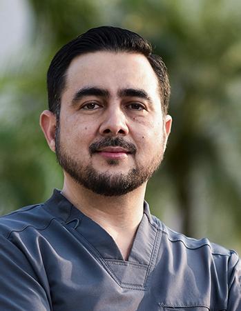 Es la foto de perfil de un oftalmólogo en Villahermosa de Hospital Angeles Villahermosa. Usa una bata médica gris. Tiene barba y cabello café oscuro.