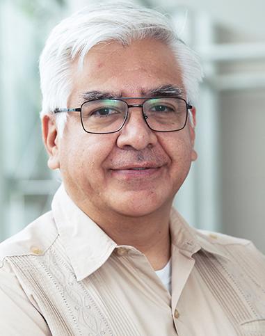 Es la foto de perfil de un cirujano general especialista en cirugía oncológica en Huixquilucan de Hospital Angeles Lomas. Usa lentes, una camisa beige y está sonriendo. 