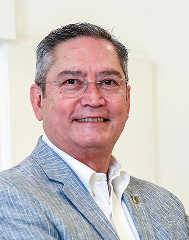 Es la foto de perfil de un cirujano general en León de Hospital Angeles León. Utiliza una saco gris, una camisa blanca y tiene lentes.