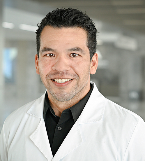 Es la foto de perfil de un ortopedista y traumatólogo en Querétaro de Hospital Angeles Centro Sur. Usa bata blanca con camisa negra y está sonriendo.