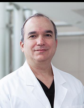 Es la foto de perfil de un cardiólogo especializado en cardiología intervencionista en Huixquilucan de Hospital Angeles Lomas. Usa bata blanca, tiene el cabello canoso y está sonriendo. 