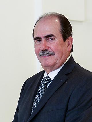 Es la foto de perfil de un odontólogo en León de Hospital Angeles León. Usa un saco negro con camisa blanca y corbata negra con rayas blancas.