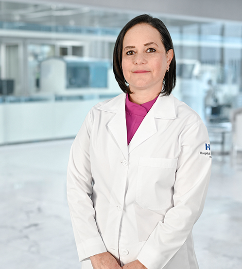 Es la foto de perfil de una ginecóloga y obstetra en Guadalajara de Hospital Angeles Del Carmen. Usa un uniforme médico de color azul aqua. Tiene el cabello corto y lacio. EStá sonriendo.