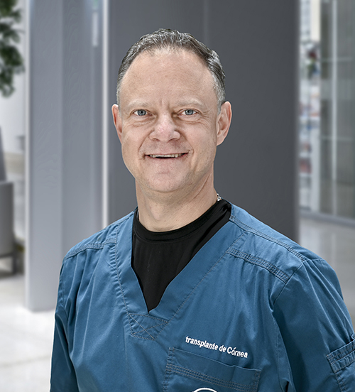 Es la foto de perfil de un oftalmólogo en Huixquilucan de Hospital Angeles Lomas. Usa un traje beige, con camisa blanca, corbata azul con puntos blancos.