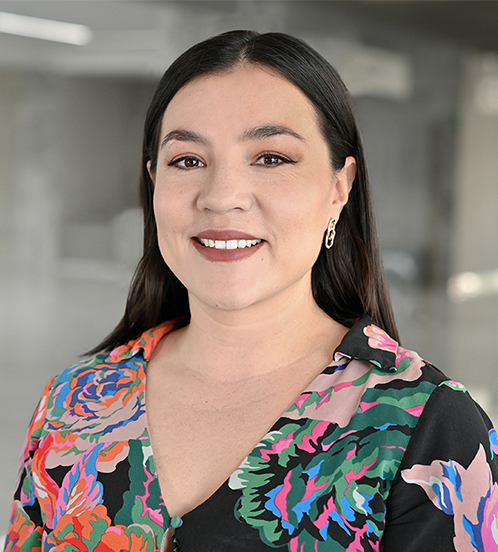 Es la foto de perfil de una gastroenteróloga pediátrica en Querétaro de Hospital Angeles Centro Sur. Usa una blusa negra con flores fosforescentes, tiene unos aretes dorados y está sonriendo.