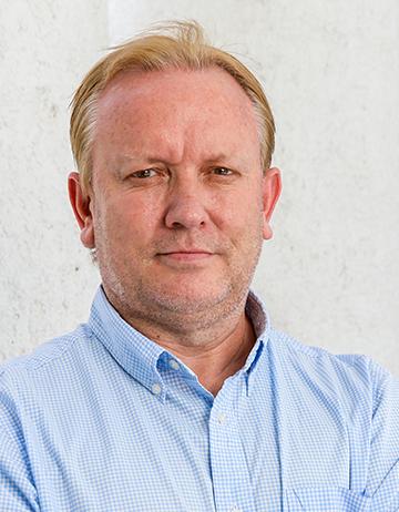 Es la foto de perfil de un urólogo en León de Hospital Angeles León. Usa una camisa azul claro, es rubio y está sonriendo ligeramente.