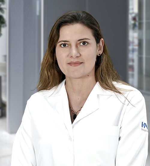 Es la foto de perfil de una ginecóloga y obstetra en Huixquilucan de Hospital Angeles Lomas. Usa una bata blanca, cabello largo ondulado y está sonriendo.