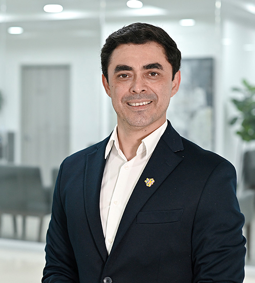 Es la foto de perfil de un urólogo ginecológico en Ciudad de México de Hospital Angeles Acoxpa. Usa un traje color azul oscuro con una camisa blanca. Tiene el cabello negro. Está sonriendo.