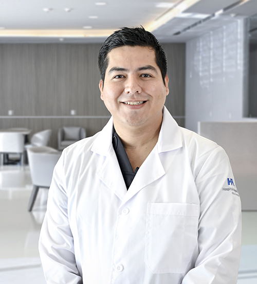 Es la foto de perfil de un ginecólogo y obstetra y cirujano robótico en San Pedro Garza García de Hospital Angeles Valle Oriente. Usa una bata blanca con un uniforme médico color azul marino. Tiene el cabello negro y está sonriendo.