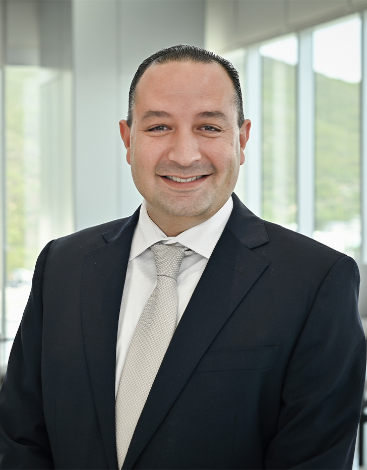 Es la foto de perfil de un ginecólogo y obstetra y especialista en medicina materno fetal en San Pedro Garza García de Hospital Angeles Valle Oriente. Usa un traje de color negro con una camisa blanca y una corbata de color gris. Tiene el cabello negro. Está sonriendo.